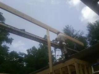 Carpenter setting a ridge beam over a new addition frame — Ice Dam Removal by Roofing Brothers in Burkittsville