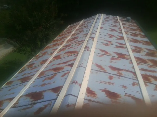 Rusted metal roof panels with new wood purlins before replacement — Storm Damage Roof Repair in Burkittsville by Roofing Brothers