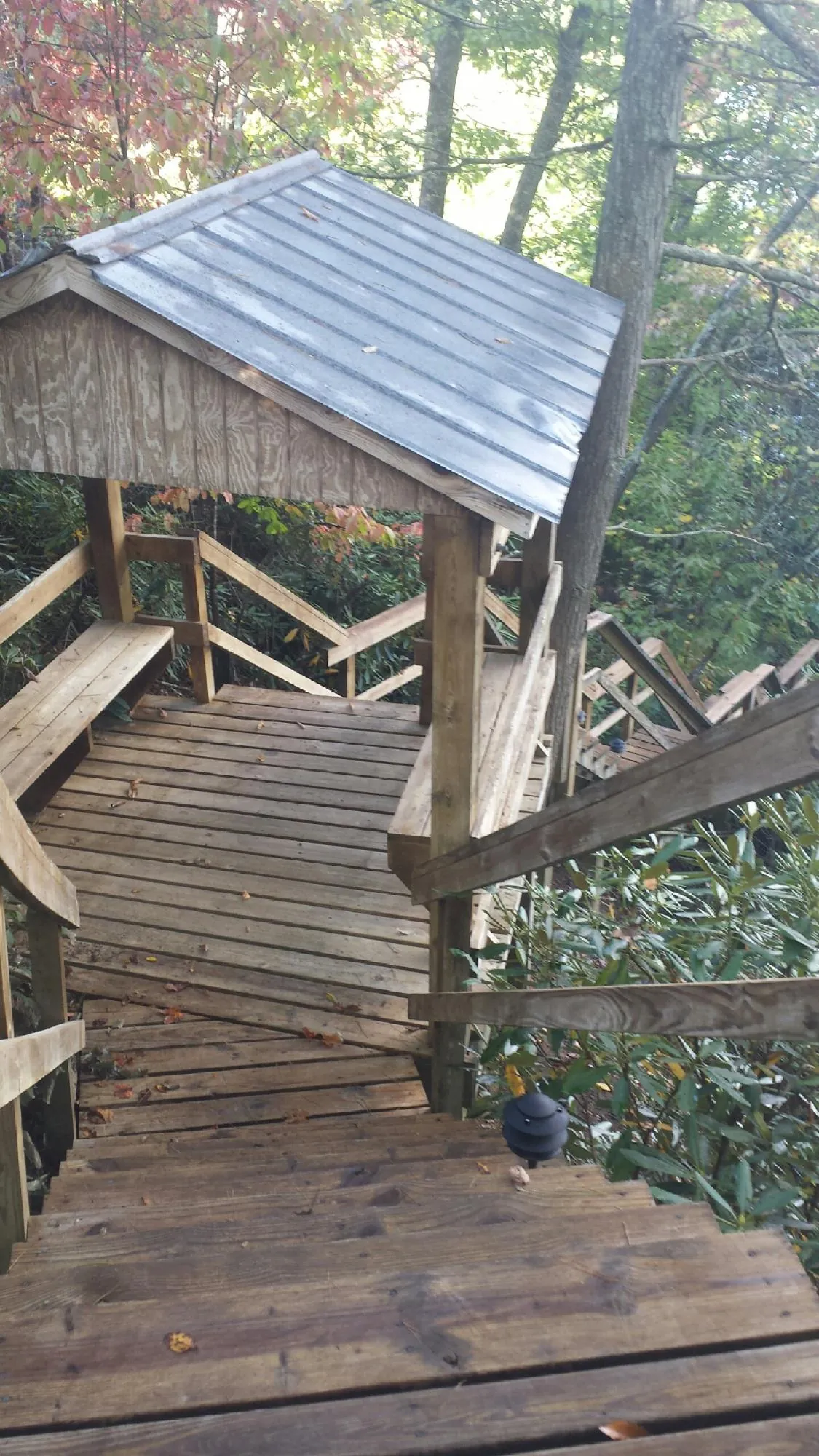 Metal roofed shelter over wooden steps on a wooded walkway — Skylight Repair & Installation work by our crew in Burkittsville
